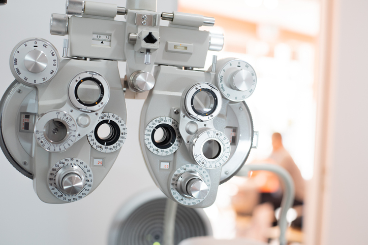 Eye examination phoropter with multiple dials used to determine vision prescription in an optometrist's office.