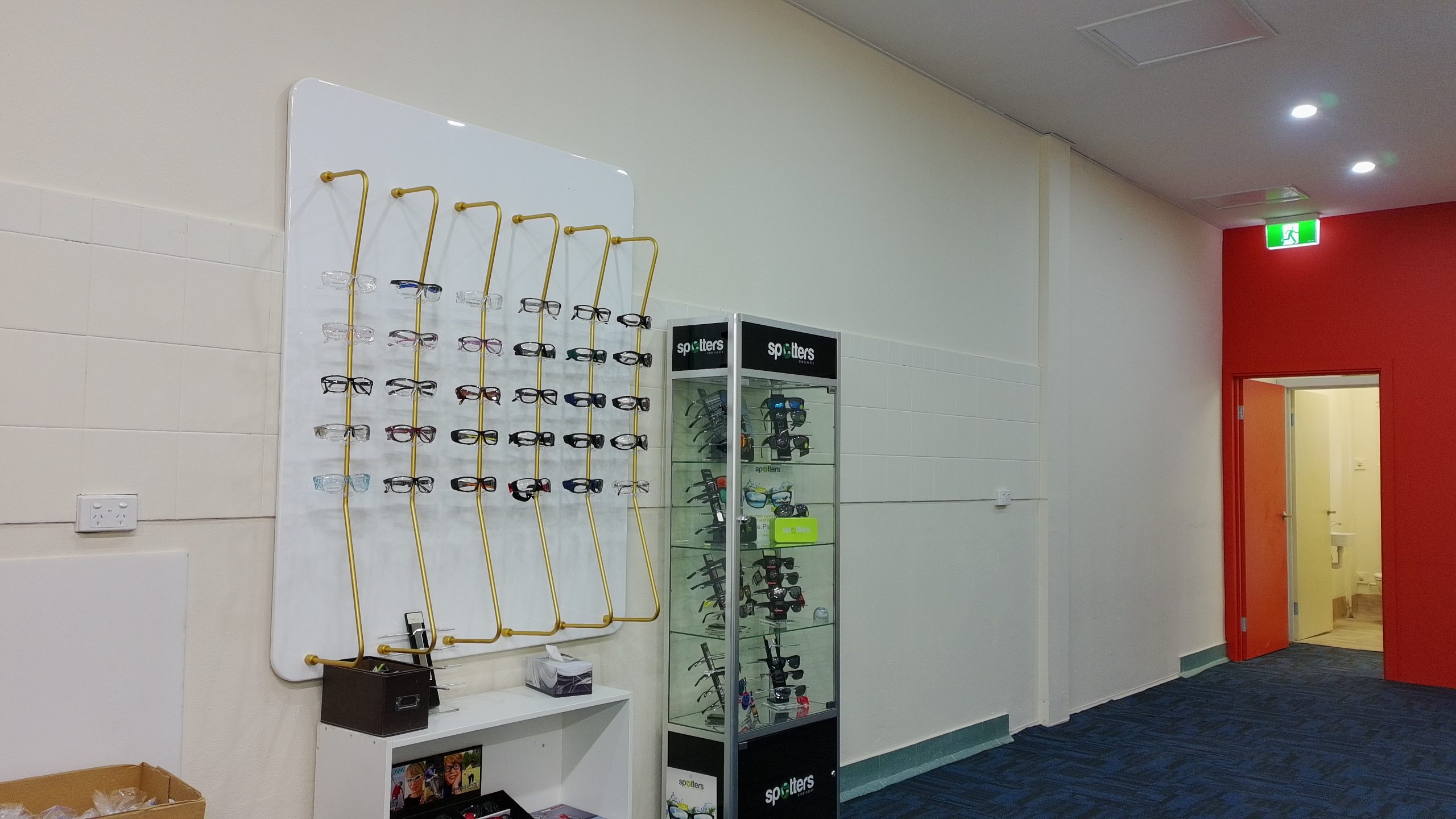 default - The Optical Superstore Eyeglass display on yellow racks with multiple frame styles in a shop interior