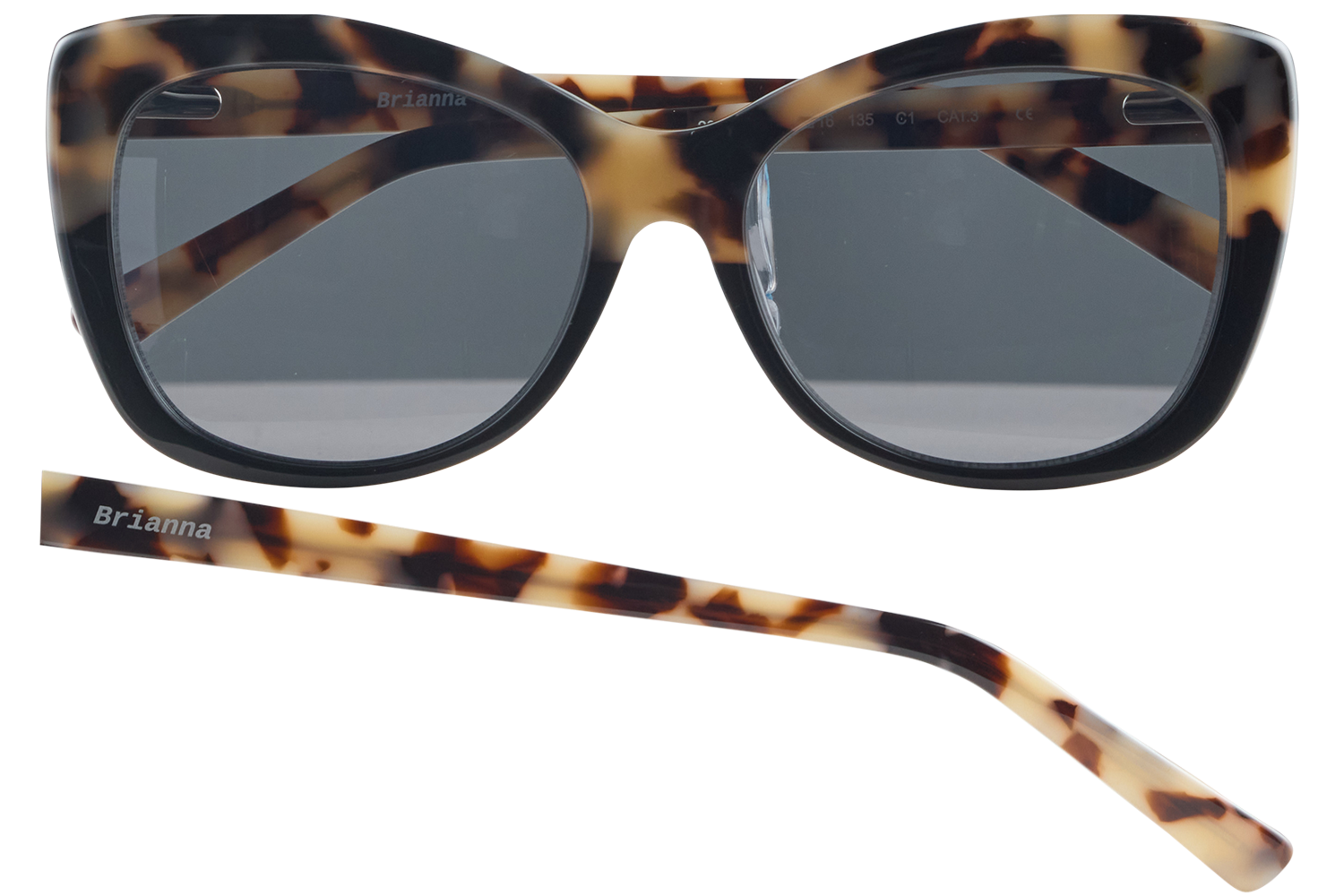 Tortoiseshell sunglasses with dark gray lenses; the name 'Brianna' is printed on the frame and a matching temple lies nearby.