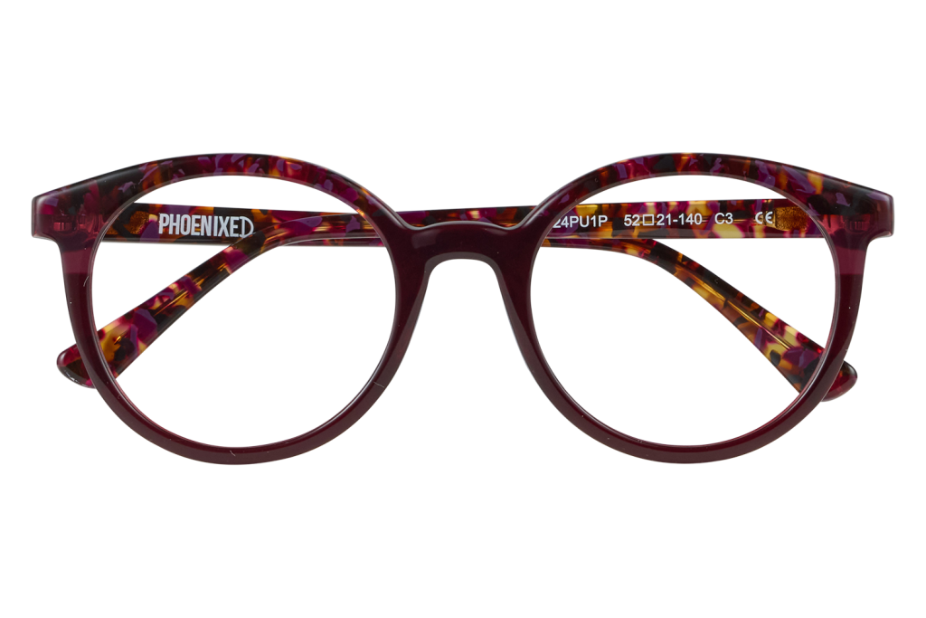 Purple tortoiseshell eyeglasses with 'PHOENIXED' on the temple, resting on a clear block.