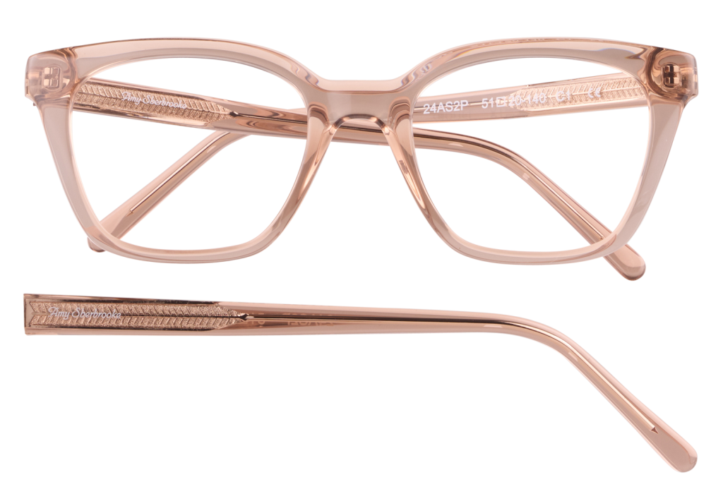 Pink transparent eyeglasses with thick rectangular frames and textured temples, brand name visible on the arm.