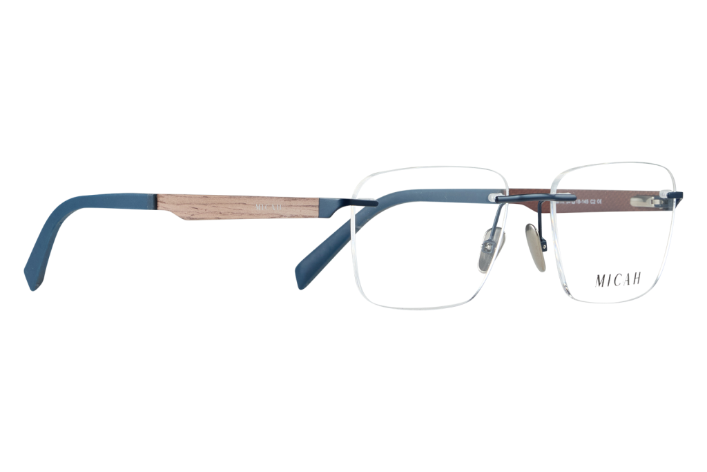 Close-up of blue-framed eyeglasses with wooden arms on a light desk; MICAH logo visible on the lens side.