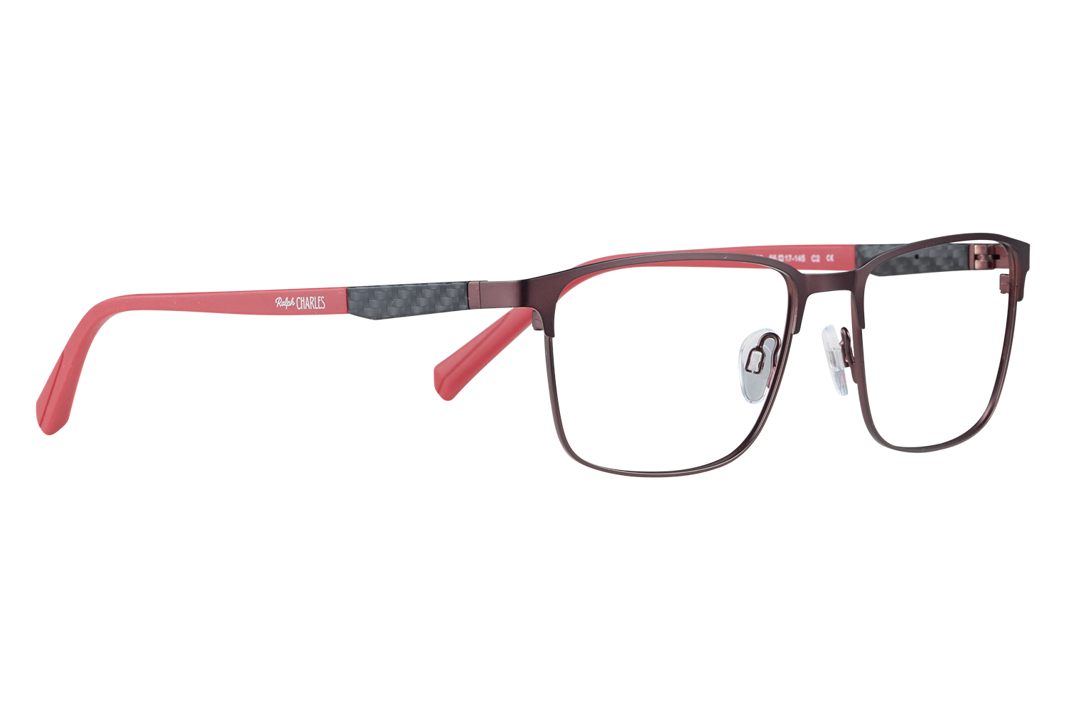 Close-up of red-framed eyeglasses with a black carbon-fiber temple detail, resting on a white surface; brand Ralph Charles visible on the arm.