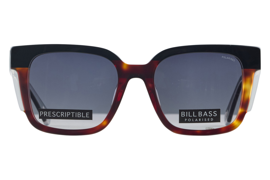 Close-up of tortoiseshell sunglasses with dark lenses and brand stickers reading PRESCRIPTIBLE and BILLBASS POLARISED across the lenses.