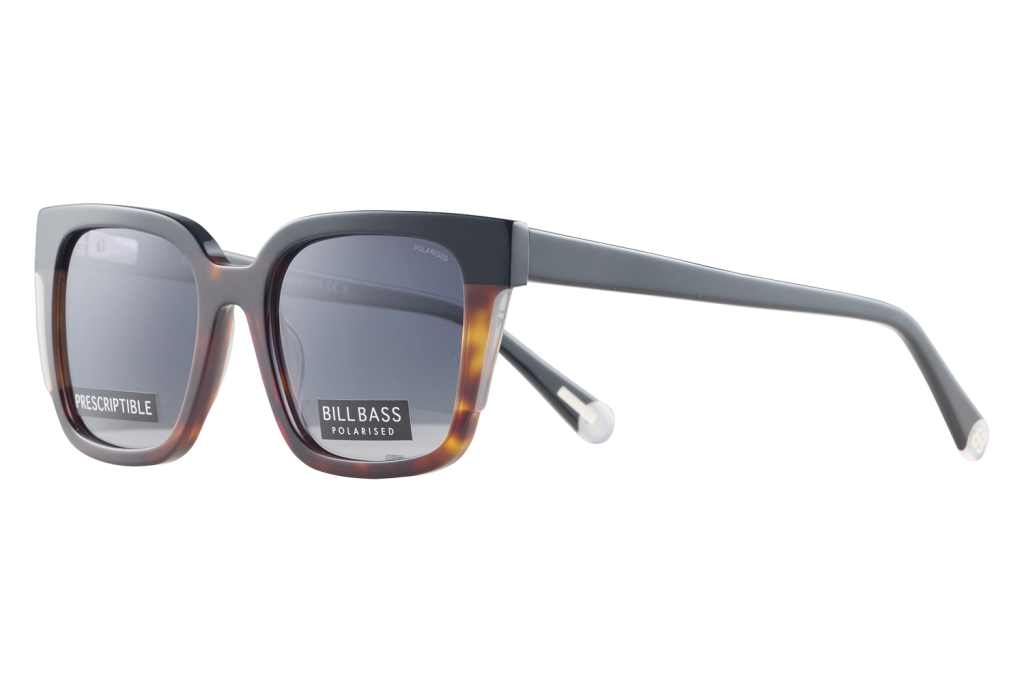 Pair of thick-framed sunglasses with grey gradient lenses; labels on the lenses read 'PRESCRIPTIBLE' and 'BILLBASS POLARISED'.