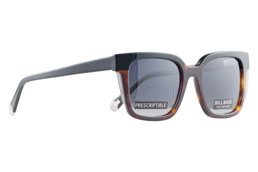 Tortoiseshell sunglasses with dark rectangular lenses and label stickers reading 'PRESCRIPTIBLE' and 'BILL BASS POLARISED'.