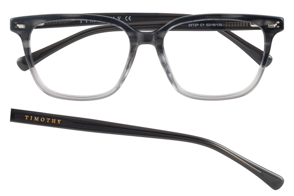 Pair of clear-frame eyeglasses with dark top section and a separate black temple bar labeled TIMOTHY; shows front and temple piece against black background.
