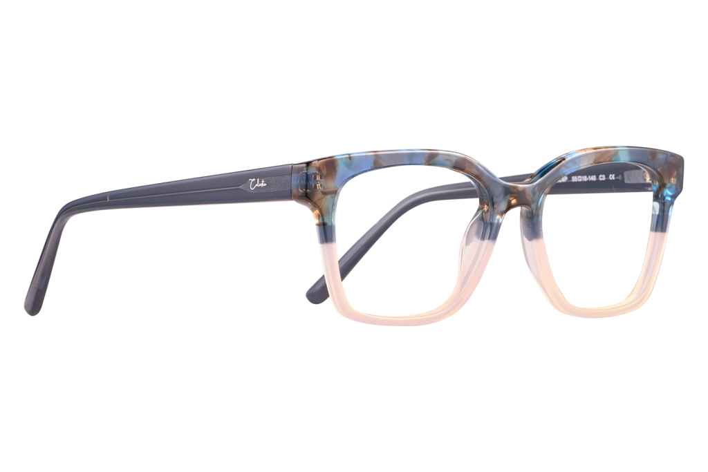 Close-up of blue-marble eyeglasses with cream lower rims and dark temples on a neutral surface (fashion eyewear).
