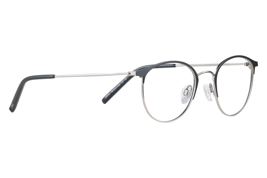 A pair of round metal-framed eyeglasses with black temples resting on a pale surface, lenses clear.