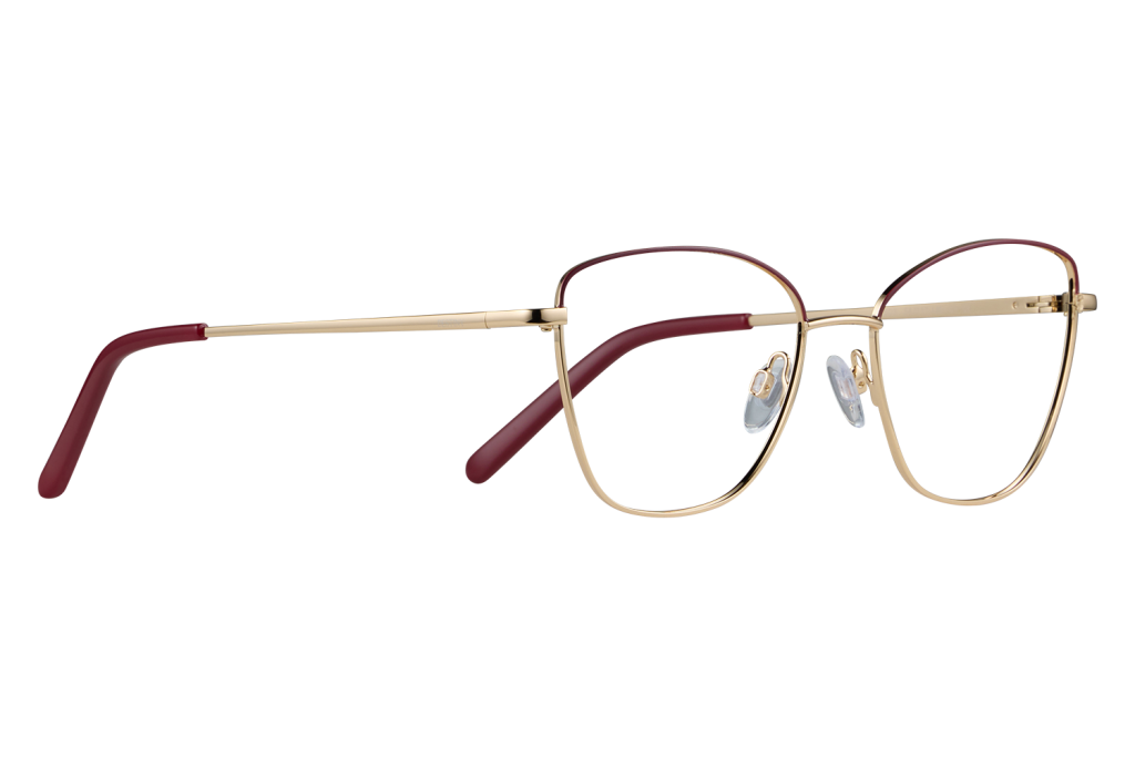 Gold pair of eyeglasses with red temple tips laid flat on a gray surface