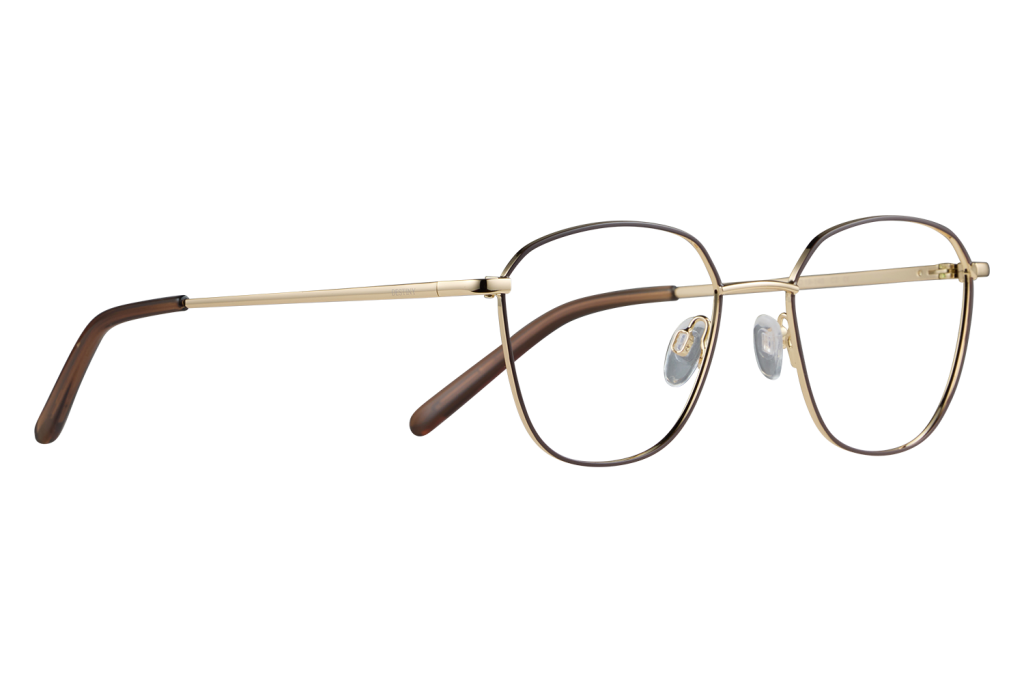 Gold-rimmed round eyeglasses with brown temples resting on a gray surface, close-up view