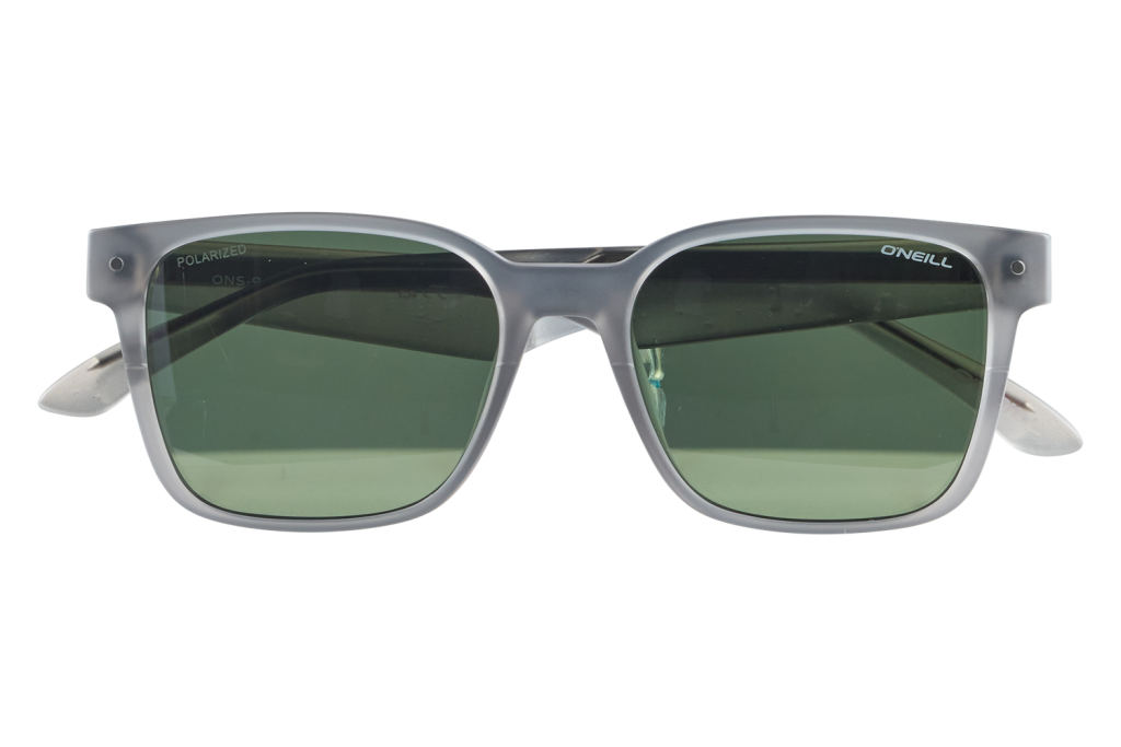 Gray-framed sunglasses with green lenses resting on a small clear stand against a white background (brand: O'Neill).